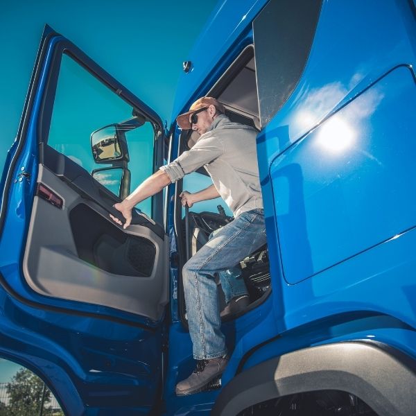 driver getting out of cab of blue truck
